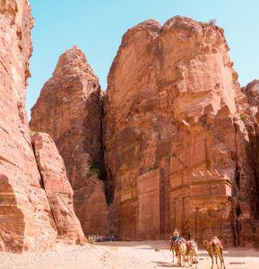PETRA, JORDAN - APRIL 25, 2016: Arab Jordanian Bedouin man rides a camel in Petra, Jordan.